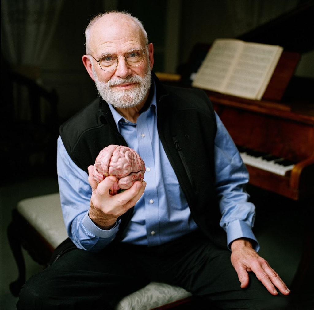 In this 2007 photo provided by the BBC, Neurologist Oliver Sacks poses at a piano while holding a model of a brain at the Chemistry Auditorium, University College London in London. Noted neurologist Oliver Sacks has found common ground with the pastor of Harlem's Abyssinian Baptist Church: Both men believe in the healing power of music. Sacks, the best-selling author of "Awakenings" and "The Man Who Mistook His Wife for a Hat," was to share the church stage Saturday with the famed gospel choir as part of the inaugural World Science Festival, a five-day celebration of science taking place in New York this week. (AP Photo/BBC, Adam Scourfield) ** NO SALES **
